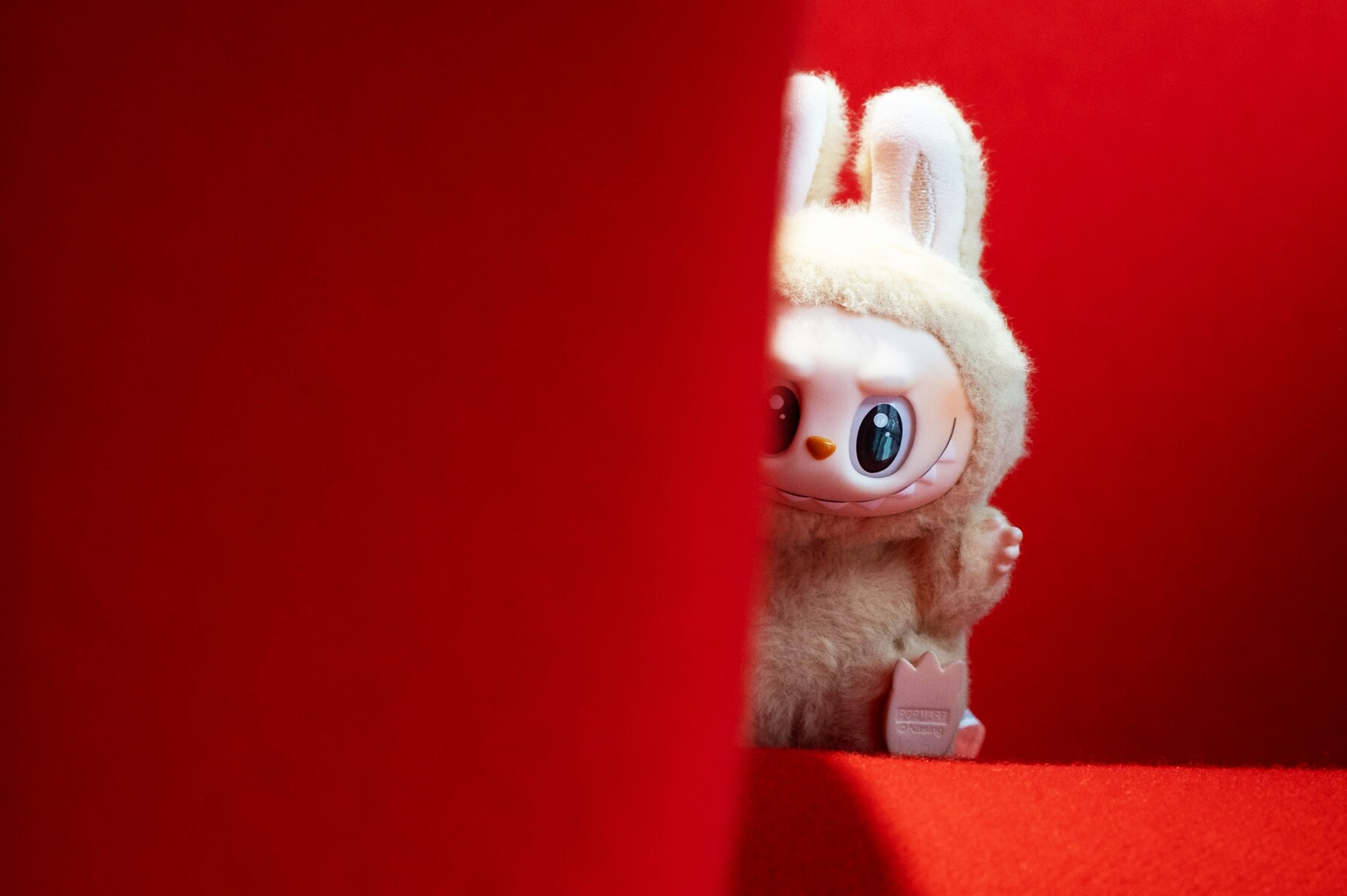 Labubu sur un fauteil rouge